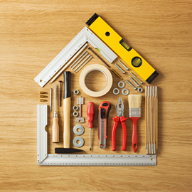 Conceptual house composed of DIY and construction tools on hardwood flooring, top view